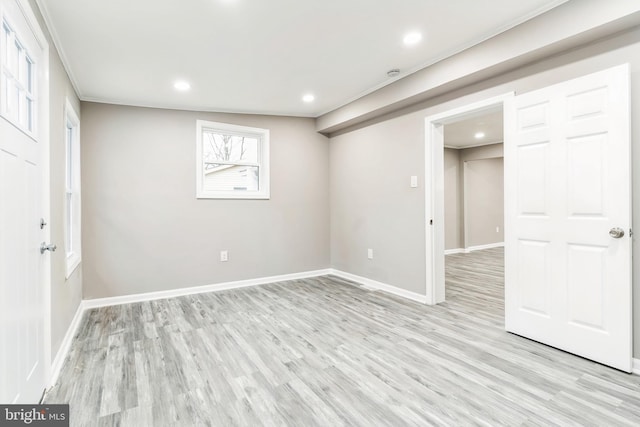 basement with crown molding and light wood-type flooring