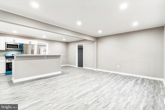 kitchen featuring white cabinetry, appliances with stainless steel finishes, a center island, and light hardwood / wood-style floors