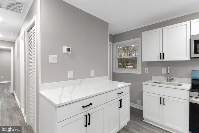 kitchen featuring sink, crown molding, light stone counters, white cabinets, and light wood-type flooring