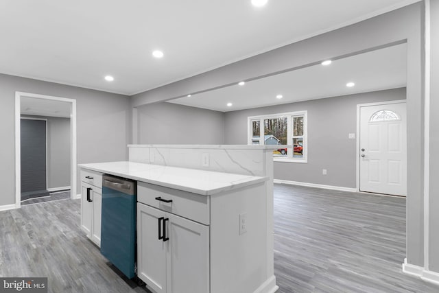 kitchen with light hardwood / wood-style flooring, light stone countertops, white cabinets, and a kitchen island