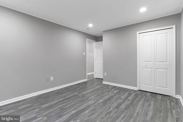 unfurnished bedroom with dark hardwood / wood-style flooring and a closet