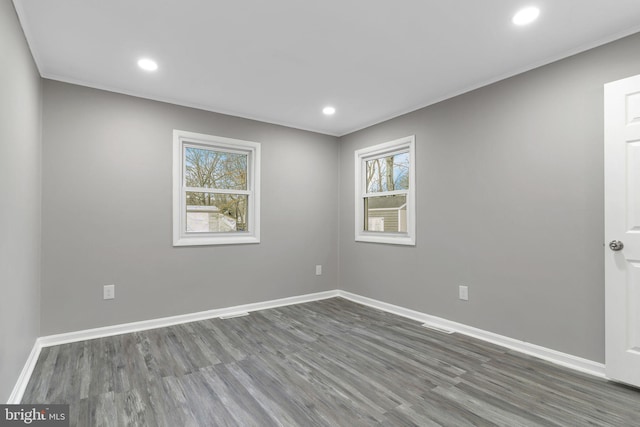 unfurnished room with ornamental molding, dark wood-type flooring, and a wealth of natural light