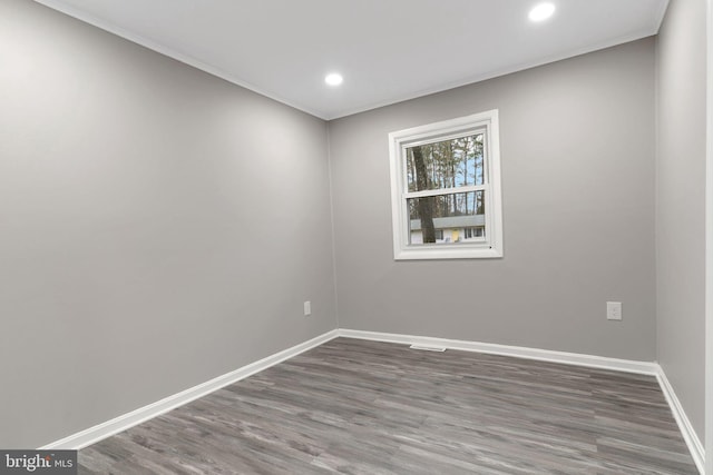 unfurnished room with ornamental molding and dark hardwood / wood-style floors