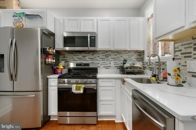 kitchen featuring white cabinetry, appliances with stainless steel finishes, and light stone countertops