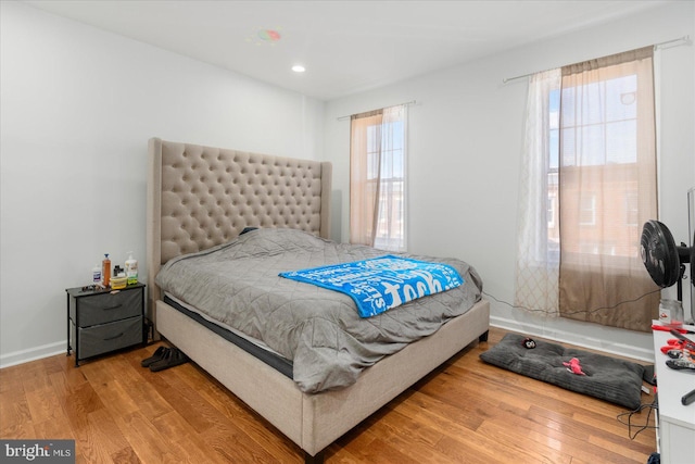 bedroom with hardwood / wood-style flooring and multiple windows