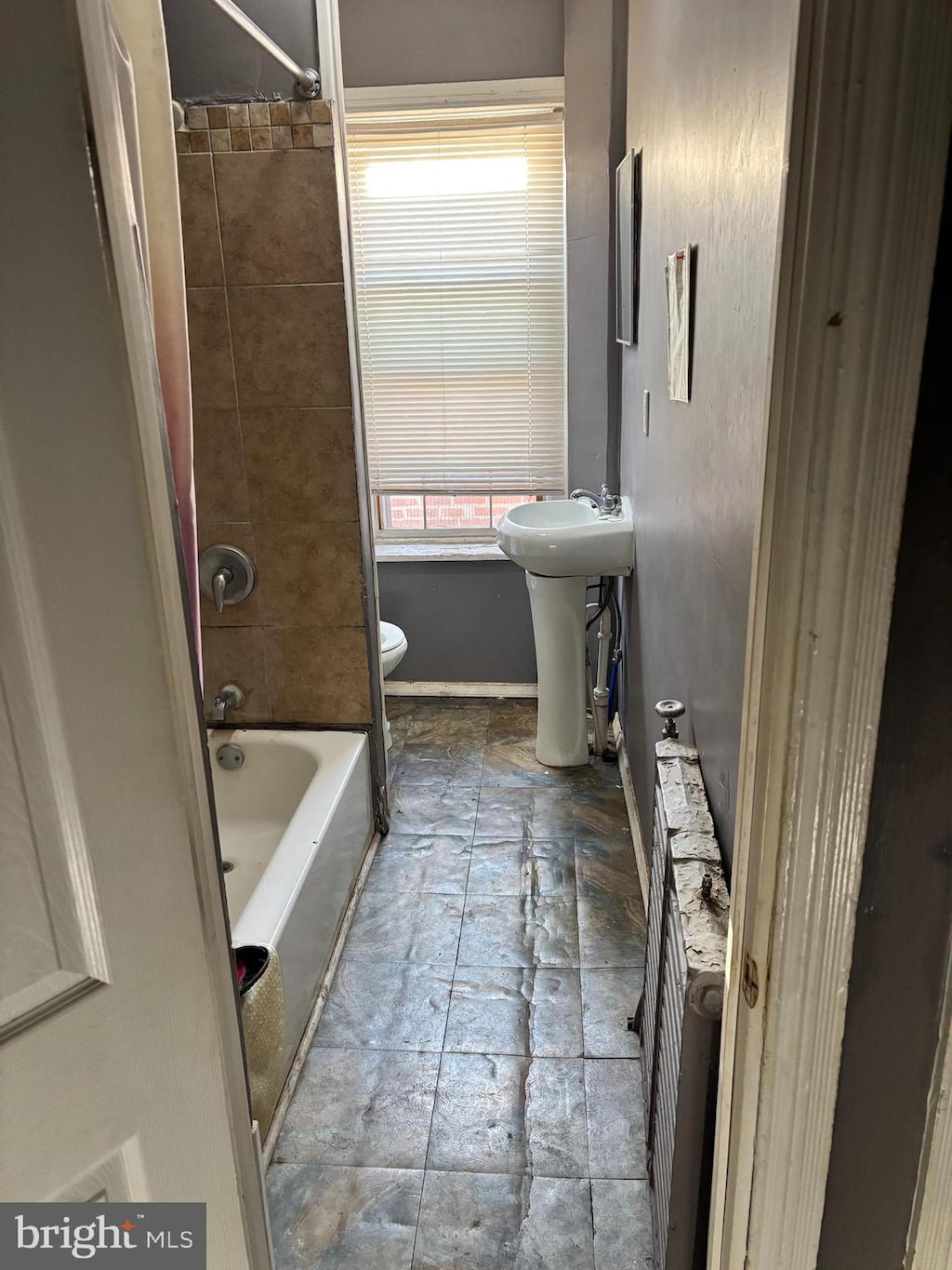 full bathroom featuring sink, tiled shower / bath, and toilet