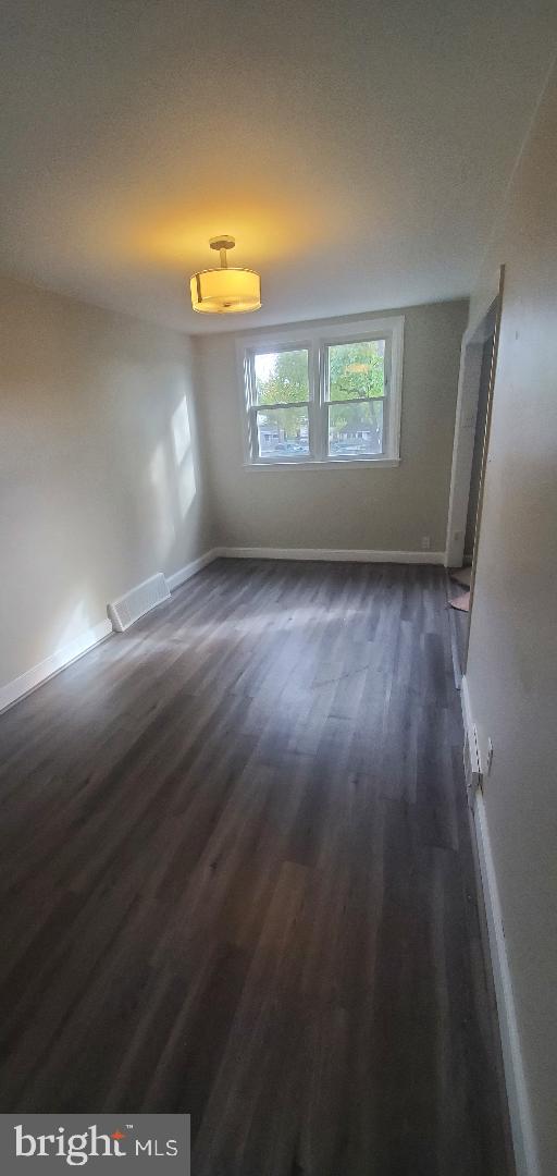 spare room with dark hardwood / wood-style floors