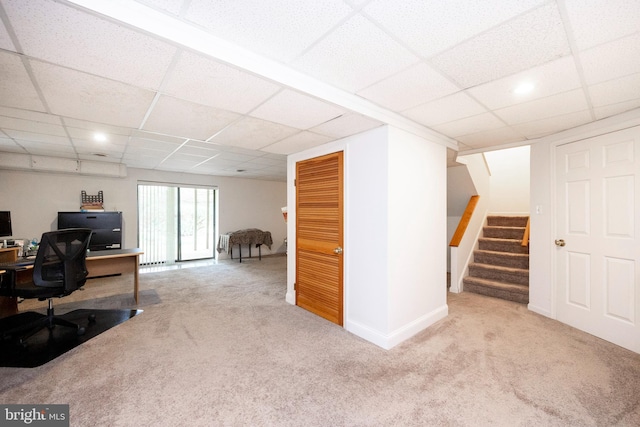 unfurnished office featuring a paneled ceiling and light carpet