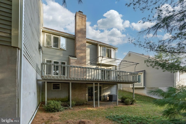 back of house with a deck, a lawn, and central AC unit