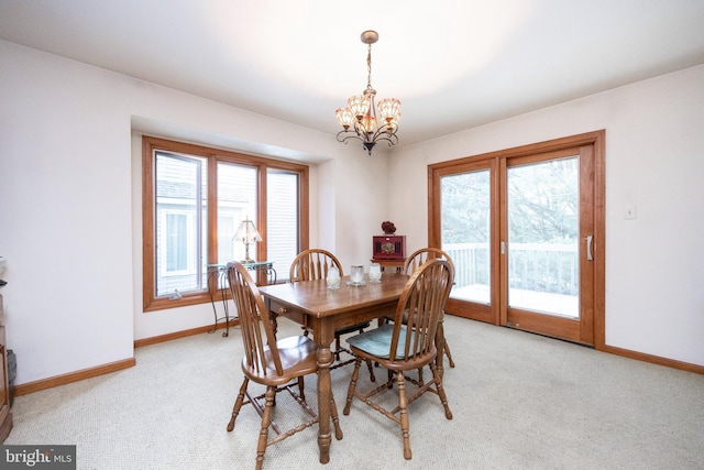 dining room featuring a chandelier and light colored carpet