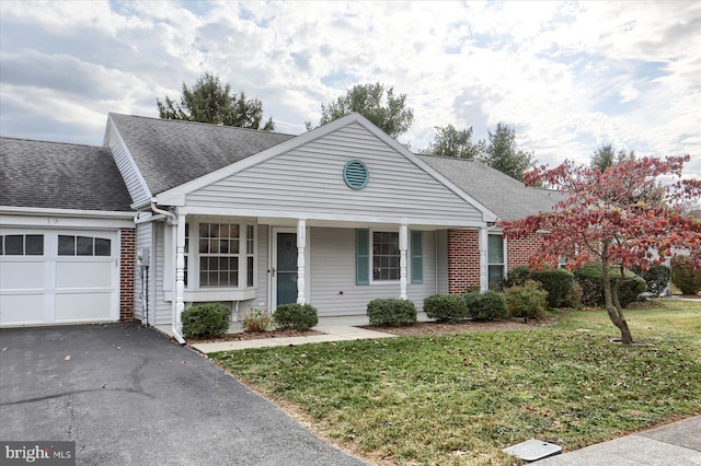 view of front of home featuring covered porch, a garage, and a front lawn