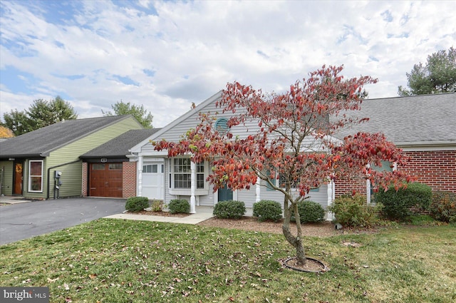 view of front of home with a garage and a front lawn