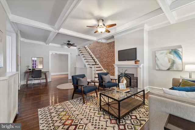 living room with coffered ceiling, ornamental molding, dark hardwood / wood-style floors, ceiling fan, and beam ceiling