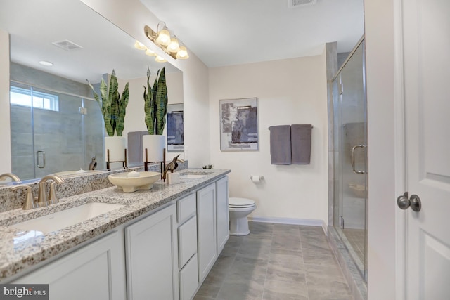 bathroom featuring a shower with door, vanity, toilet, and tile patterned flooring