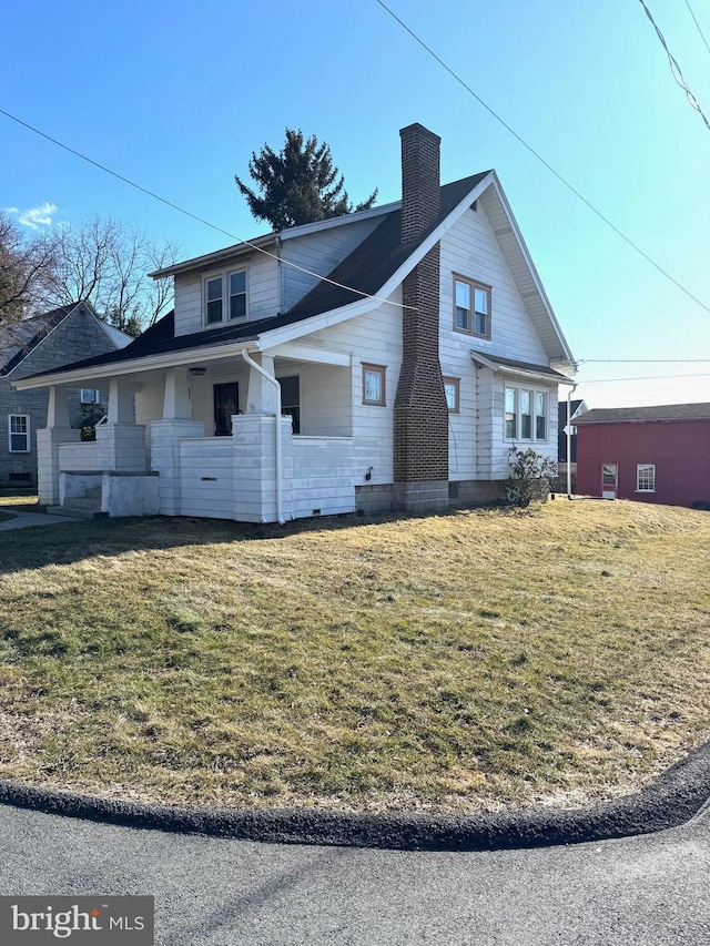 view of side of home with a chimney and a lawn