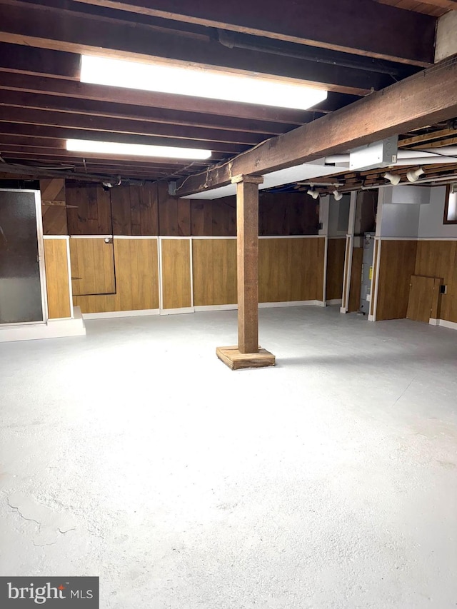 unfinished basement featuring wooden walls