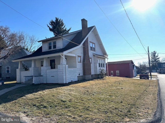 view of property exterior featuring a porch, a yard, and a chimney