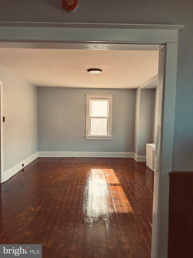 unfurnished room featuring dark wood finished floors and baseboards