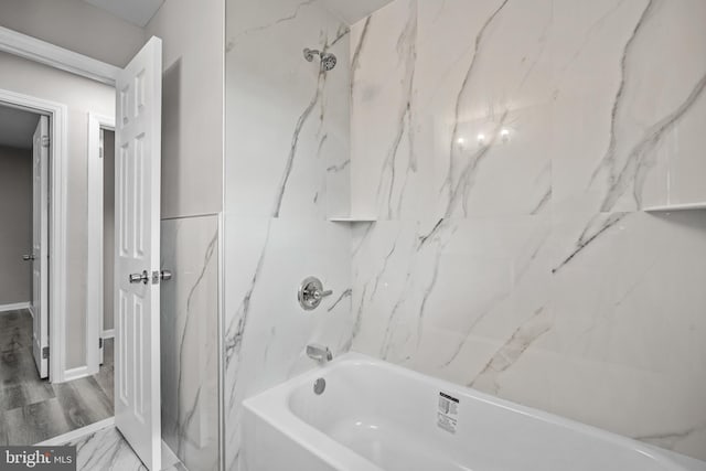 bathroom with tiled shower / bath combo and wood-type flooring