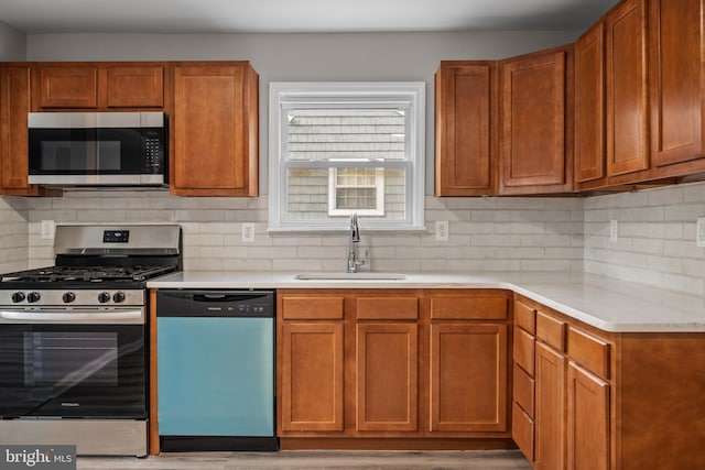 kitchen with tasteful backsplash, sink, stainless steel appliances, and light hardwood / wood-style flooring