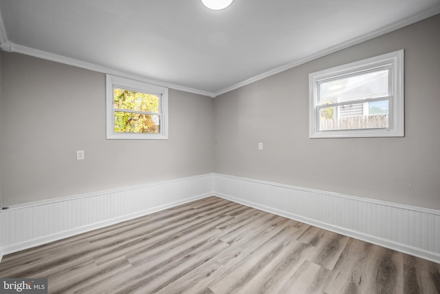 empty room with light wood-type flooring and crown molding