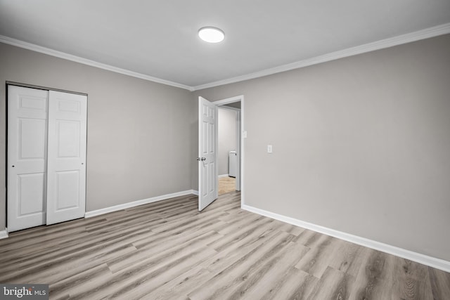 unfurnished bedroom featuring light hardwood / wood-style floors, crown molding, and a closet