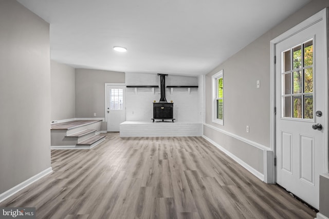 unfurnished living room with hardwood / wood-style floors and a wood stove