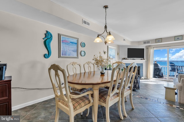 tiled dining area featuring a chandelier