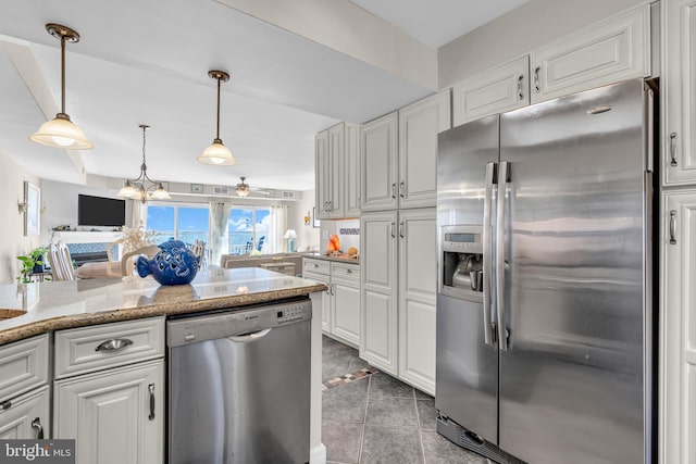 kitchen featuring white cabinets, appliances with stainless steel finishes, decorative light fixtures, and light stone countertops