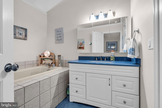 bathroom featuring tiled bath and vanity