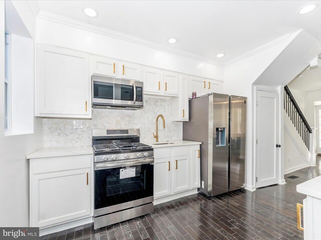 2592 Druid Park Dr, Baltimore, MD 21215 - kitchen featuring appliances with stainless steel finishes, a sink, light countertops, white cabinetry, and crown molding