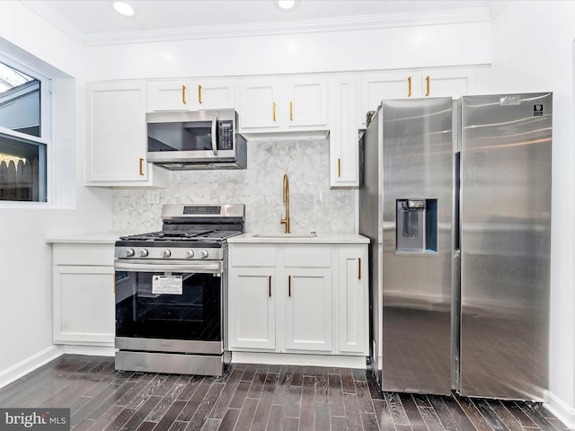 kitchen featuring white cabinetry, sink, dark wood-type flooring, appliances with stainless steel finishes, and ornamental molding