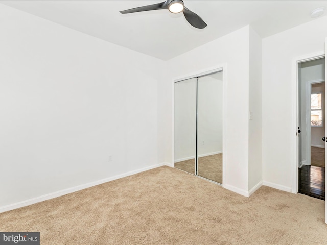 unfurnished bedroom with light carpet, a closet, and ceiling fan