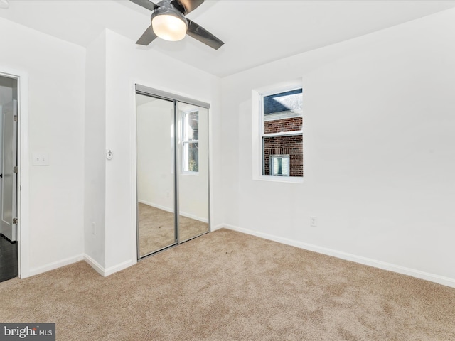 unfurnished bedroom featuring ceiling fan, a closet, and light carpet