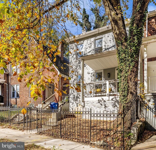 2592 Druid Park Dr, Baltimore, MD 21215 - view of front of house with a fenced front yard, a porch, and brick siding