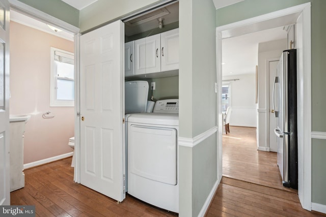 washroom featuring cabinets, hardwood / wood-style floors, washing machine and clothes dryer, and a healthy amount of sunlight