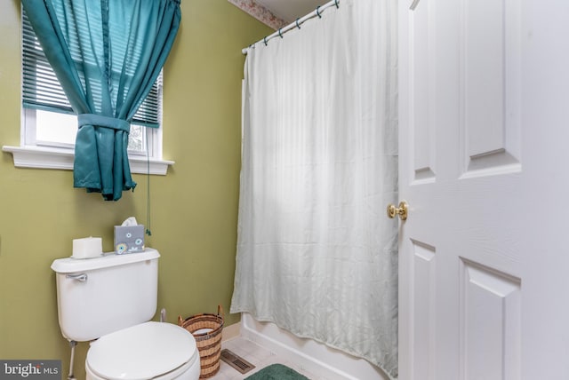 bathroom featuring tile patterned flooring, shower / tub combo with curtain, and toilet