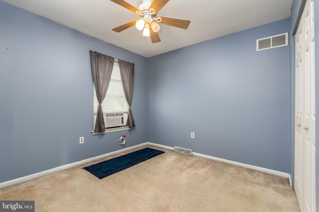 carpeted spare room featuring cooling unit and ceiling fan