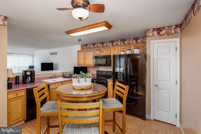 kitchen featuring kitchen peninsula, ceiling fan, sink, black appliances, and light parquet flooring