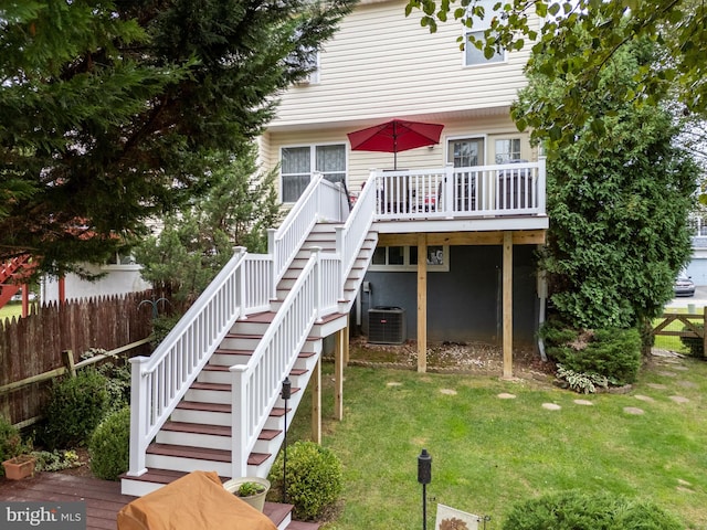 rear view of property with central air condition unit, a deck, and a lawn