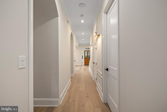 hallway with ornamental molding and light wood-type flooring