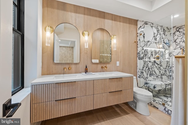 bathroom featuring tile walls, vanity, toilet, and a shower