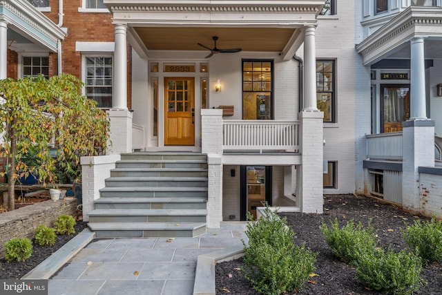 view of exterior entry with ceiling fan and a porch