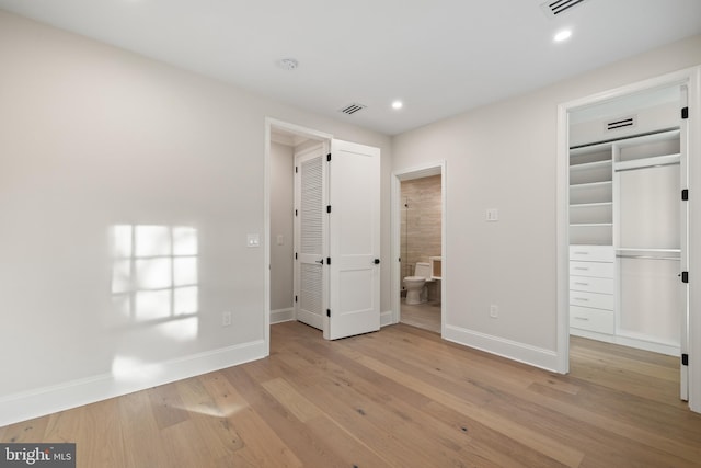 unfurnished bedroom with a closet and light hardwood / wood-style floors