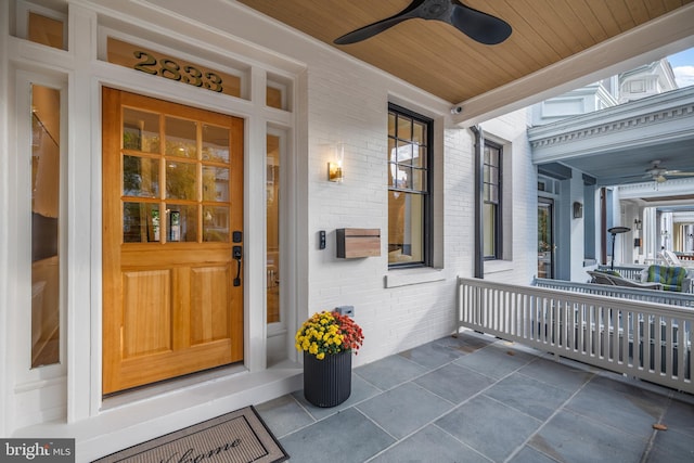 doorway to property featuring ceiling fan and a porch