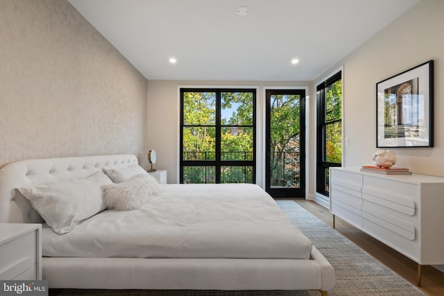 bedroom featuring access to exterior and hardwood / wood-style floors