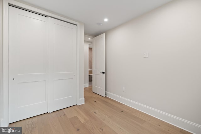 unfurnished bedroom with a closet and light hardwood / wood-style floors