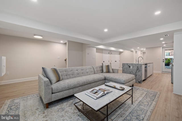 living room with sink and light wood-type flooring