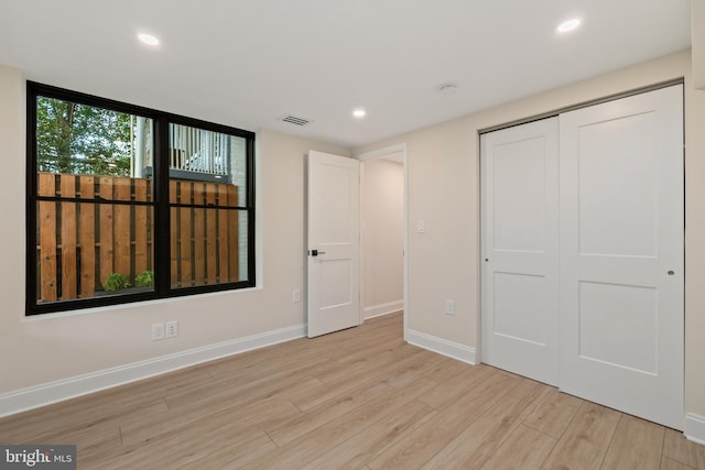 unfurnished bedroom featuring a closet and light hardwood / wood-style floors