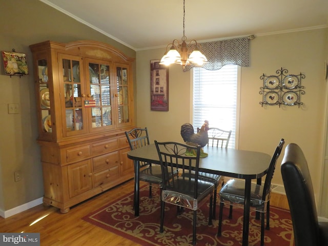 dining area featuring wood-type flooring, a chandelier, and crown molding